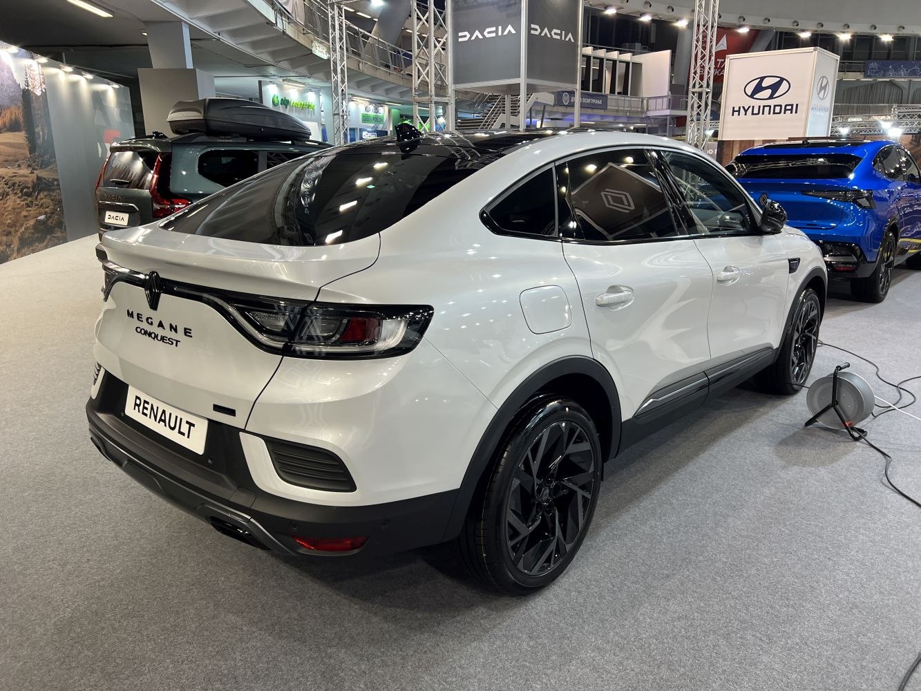 Rear and side view of white modern sedan with black alloy wheels and sleek taillights