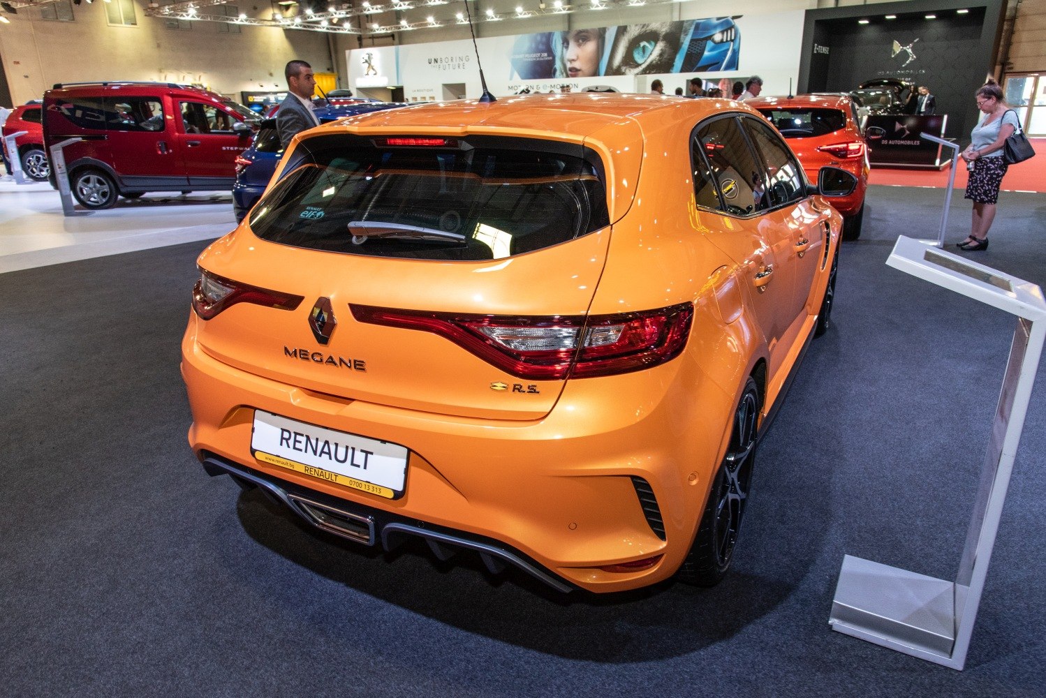 Rear view of sporty orange hatchback with distinctive lights and diffuser