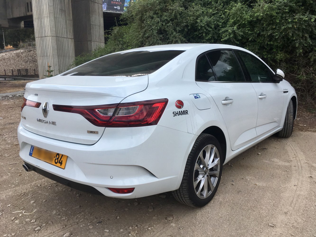 Rear view of white sedan with LED tail lights and alloy wheels