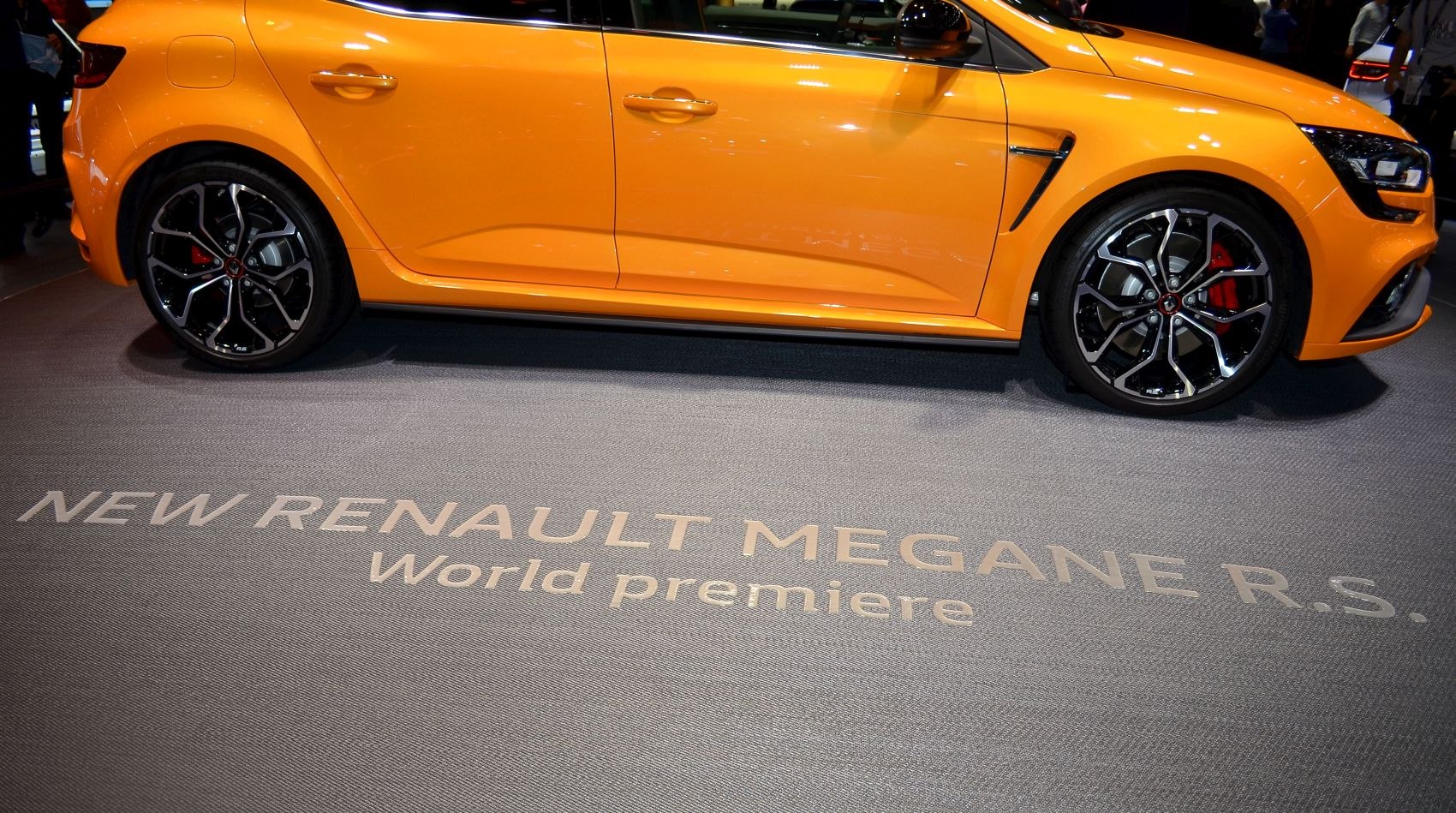 Side view showing sporty alloy wheels and vibrant orange body