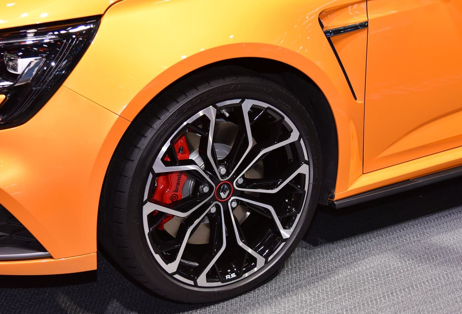 Close-up of multi-spoke alloy wheel and red Brembo brake caliper