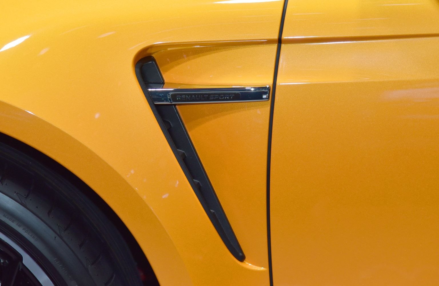 Side fender vent with Renault Sport badge on yellow painted panel