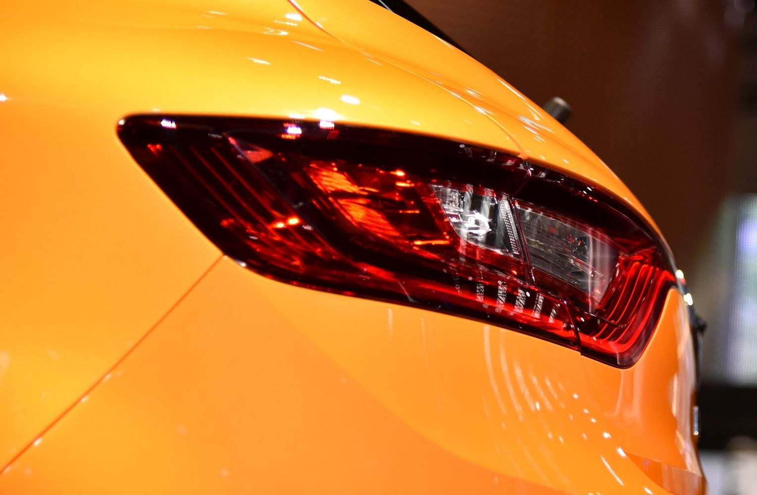 Close-up of a red rear light on orange vehicle body