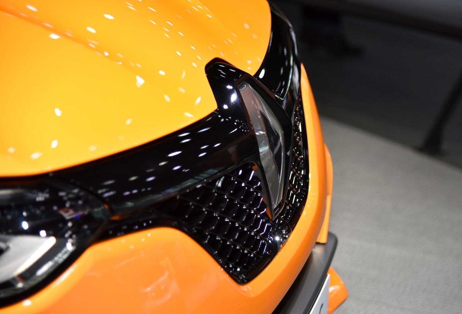 Close-up of front grille and Renault emblem on bright car hood