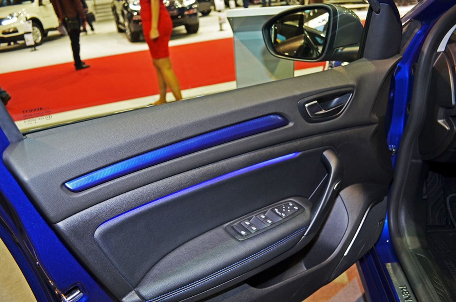 Car door panel with blue ambient lighting and window controls