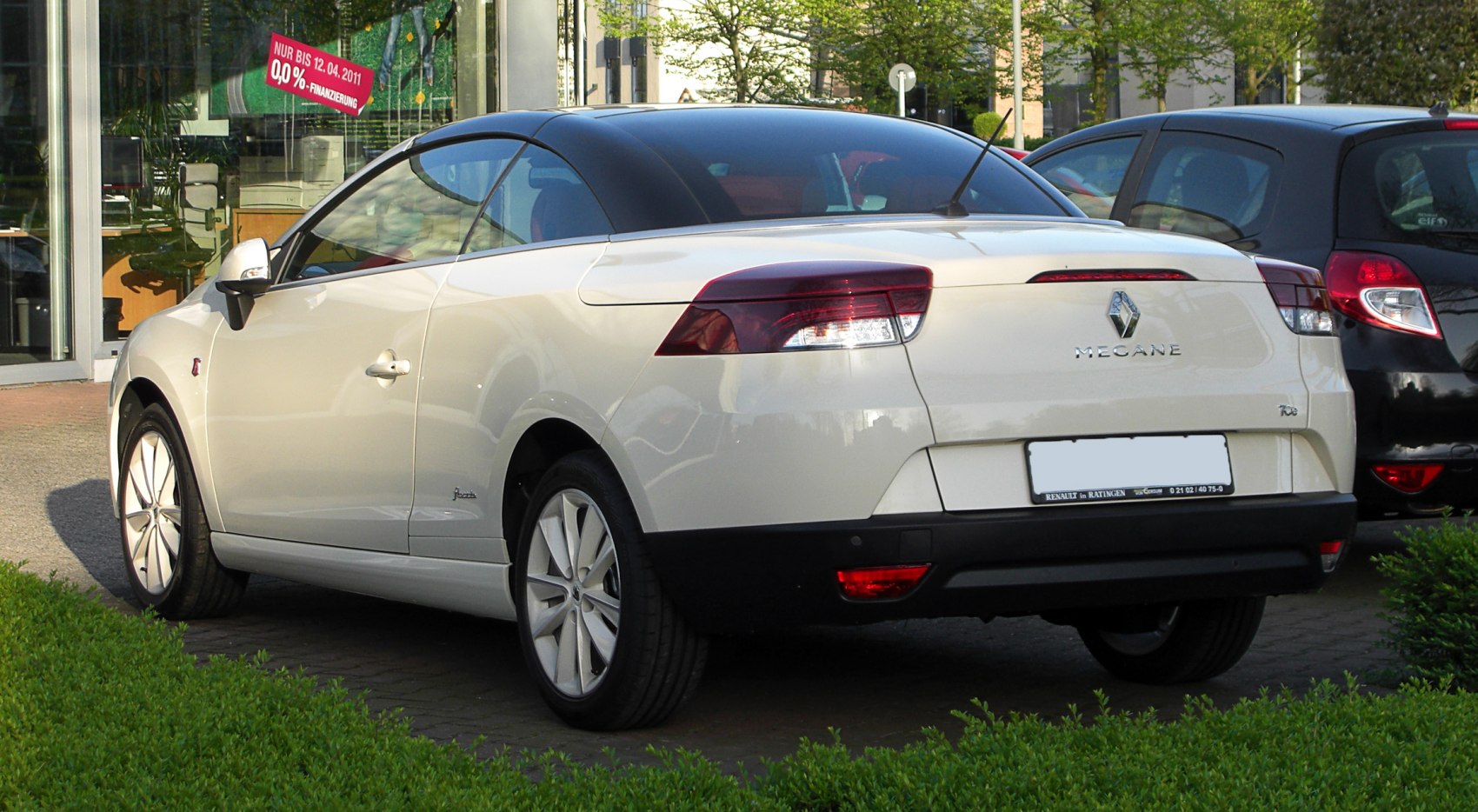 Rear view of white convertible with black roof and alloy wheels
