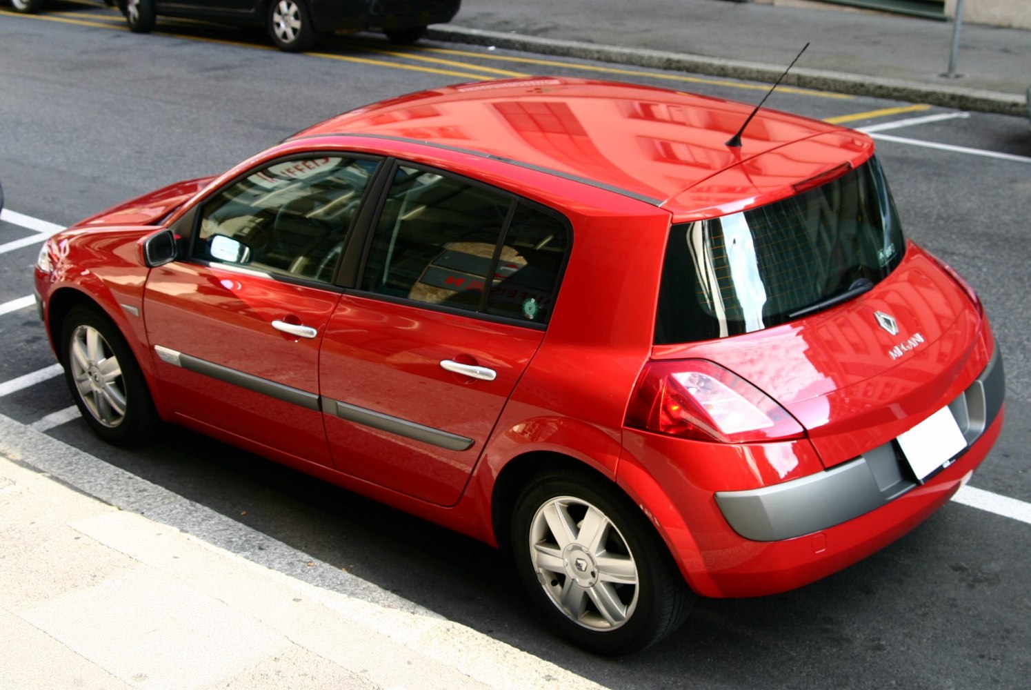Red compact hatchback with distinctive rear lights and side molding