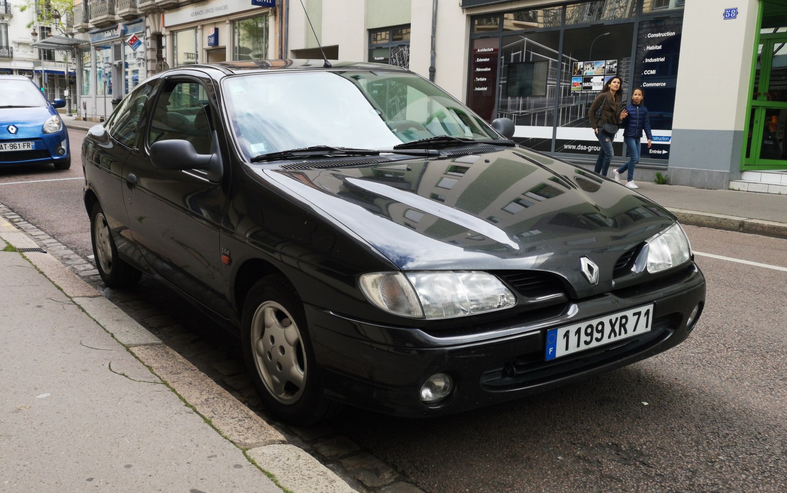 Front and side view of a black coupe with distinct headlights and smooth body lines.
