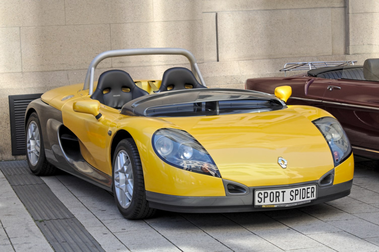 Yellow open-top two-seater roadster with distinctive aerodynamic styling