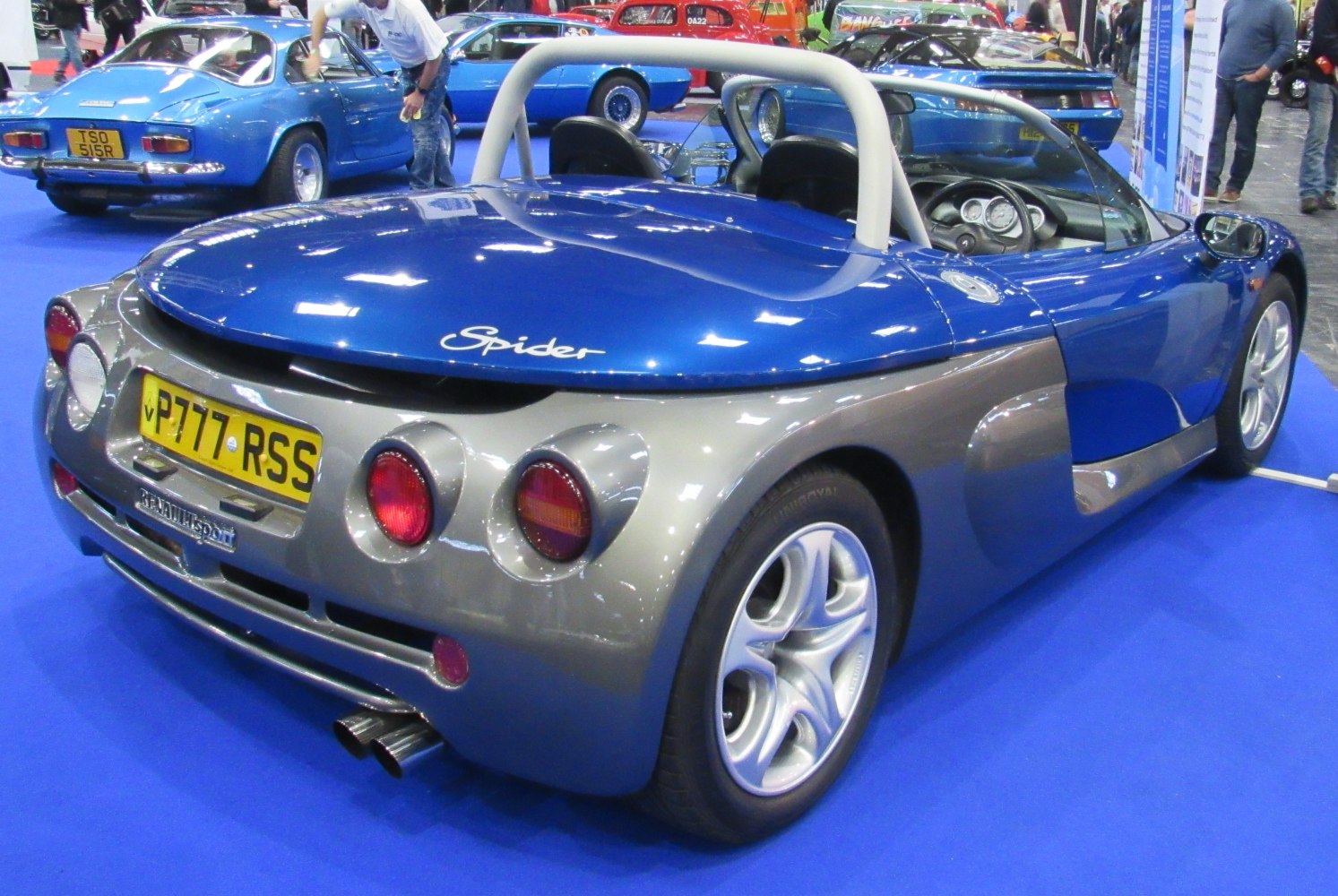 Rear view of open-top sports car with round tail lights and dual exhaust