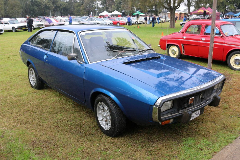 Blue sporty 1970s two-door coupé with hood scoop and alloy wheels.