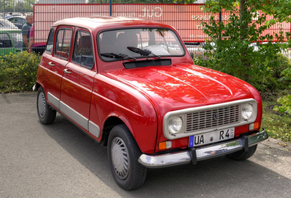 Red vintage compact car with rounded headlights and chrome bumper