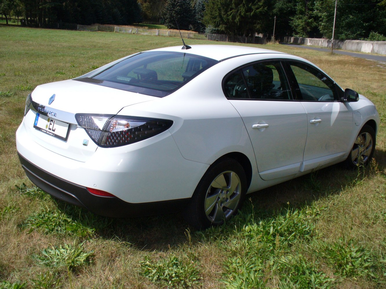 Rear and side view of white electric sedan with distinctive taillights