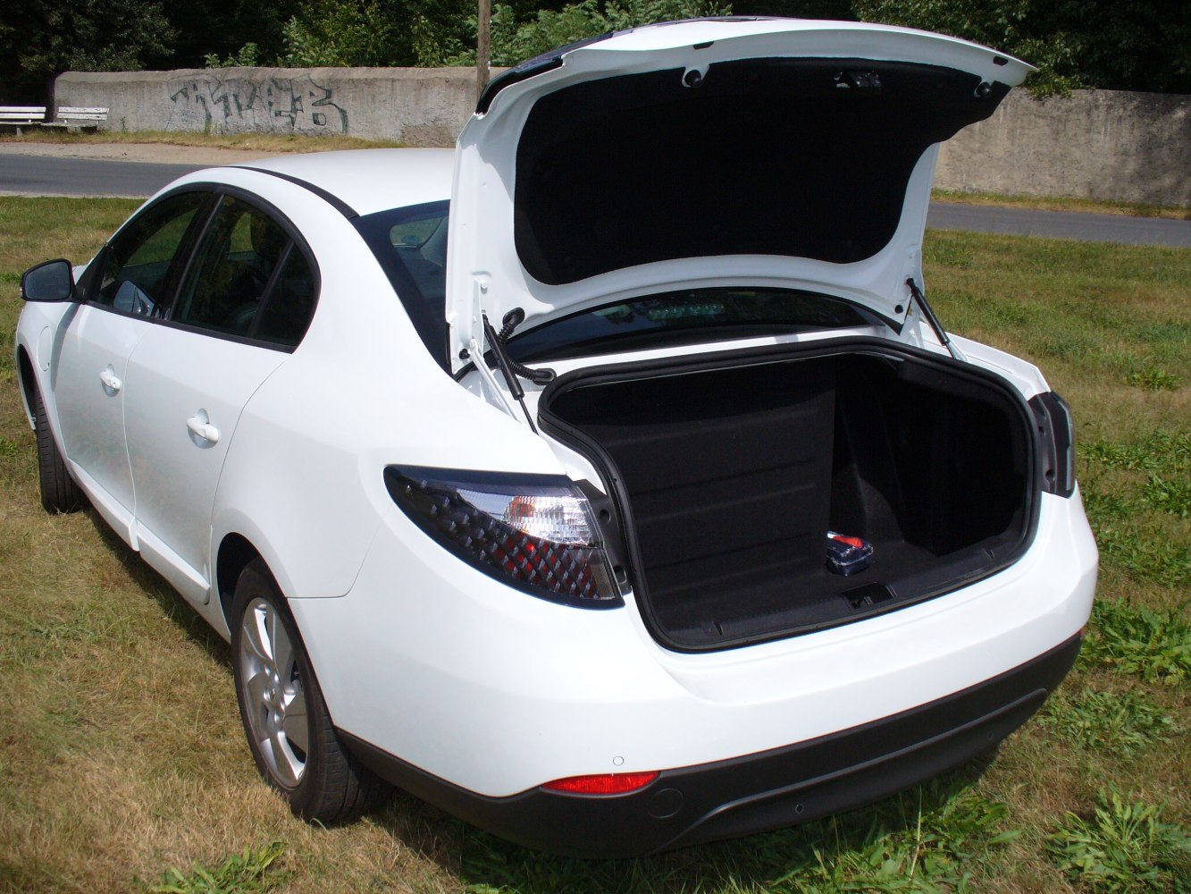 Open trunk of a white electric sedan showing spacious cargo area