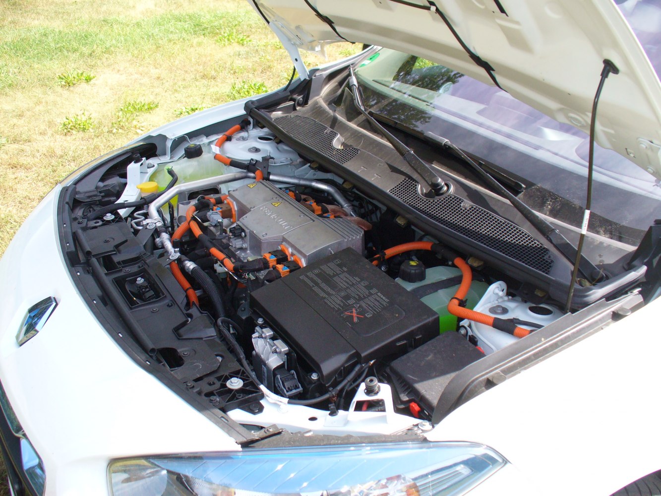 Electric motor and bright orange wiring cables in engine bay