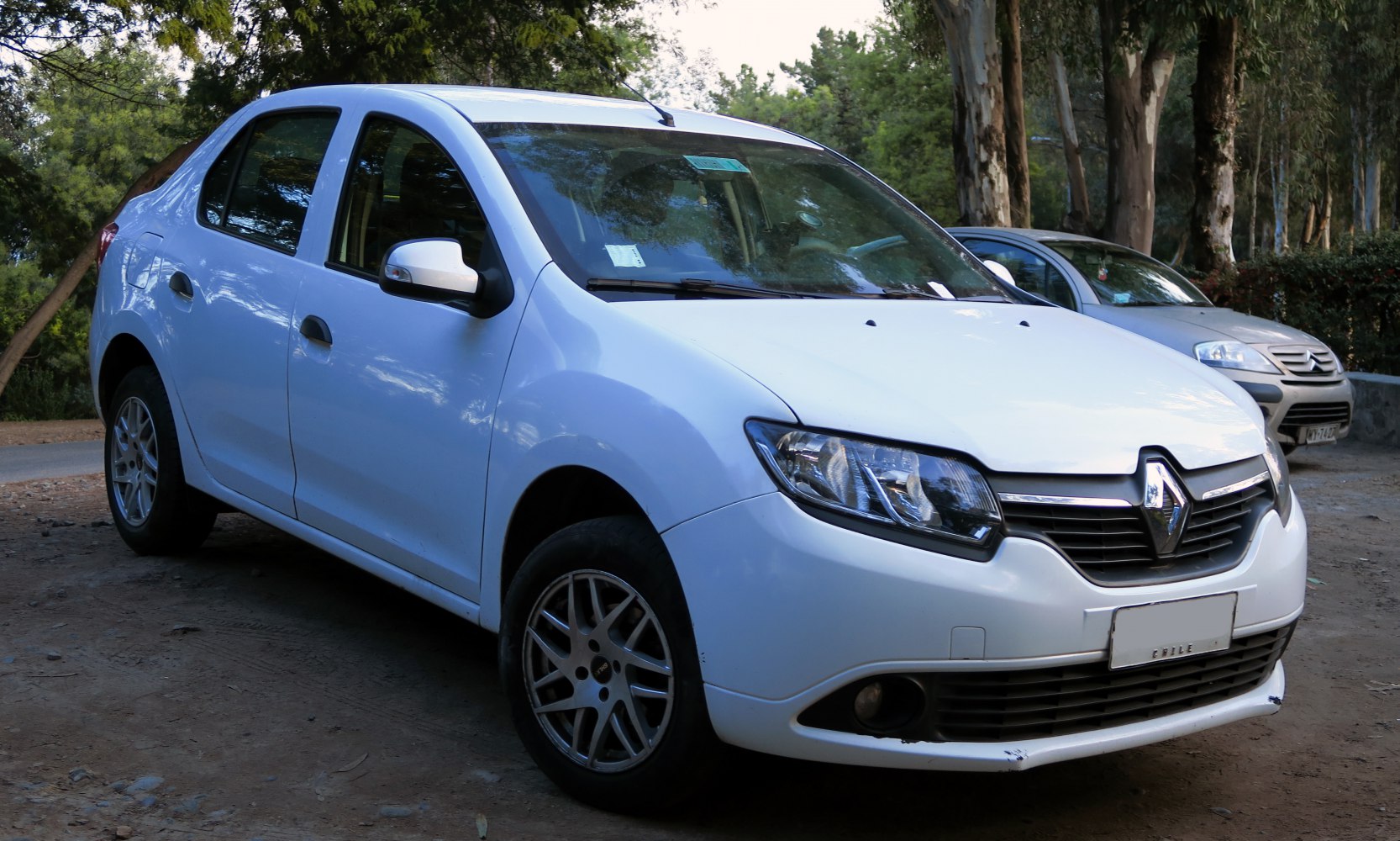 Front three-quarter view of white sedan with distinct grille and headlights