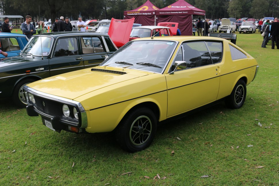 Yellow vintage coupe with dual round headlights and rear side louvers