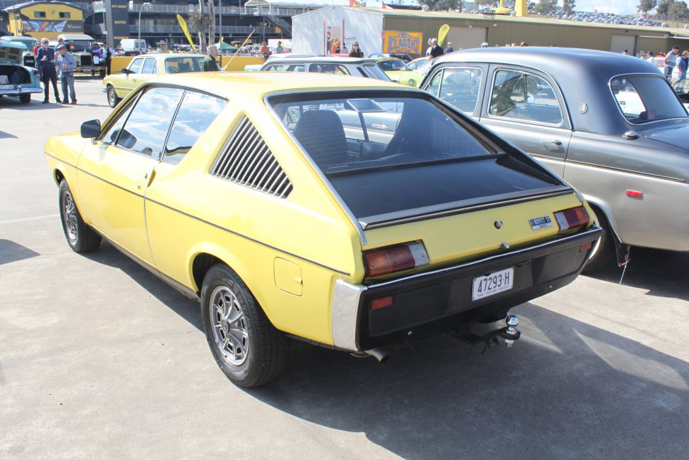 Yellow fastback car with vented side panels and angled rear window