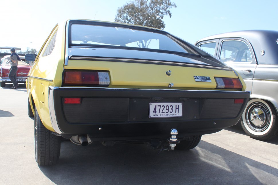 Yellow classic car rear with distinct lights and tow hitch