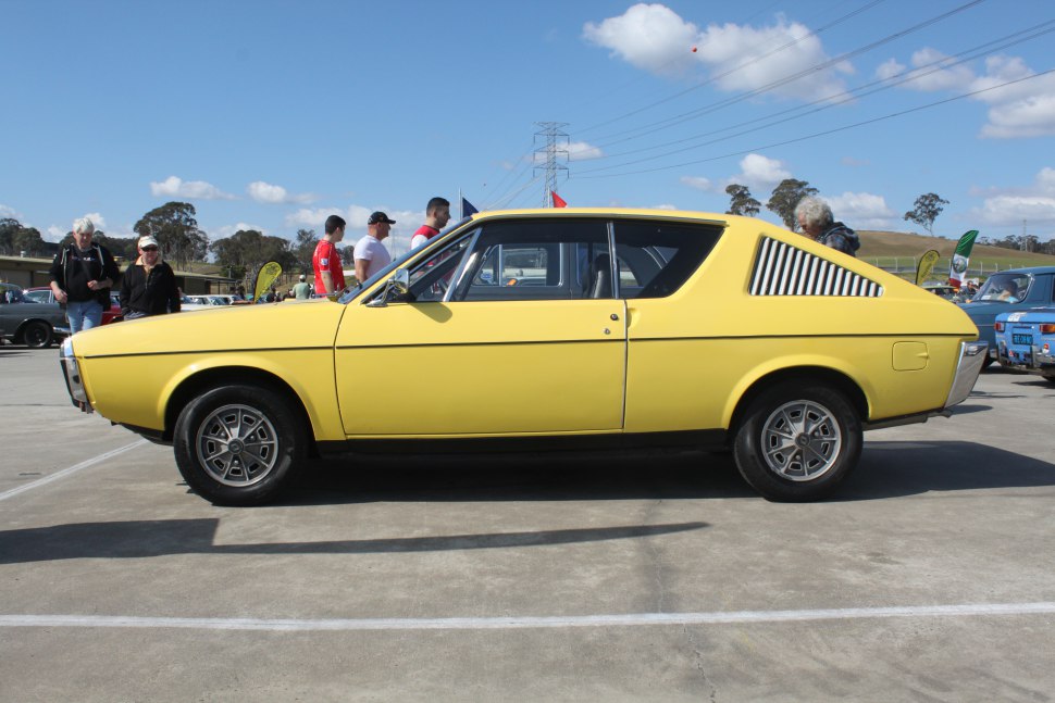 Yellow 1970s coupe with rear side vents and alloy wheels