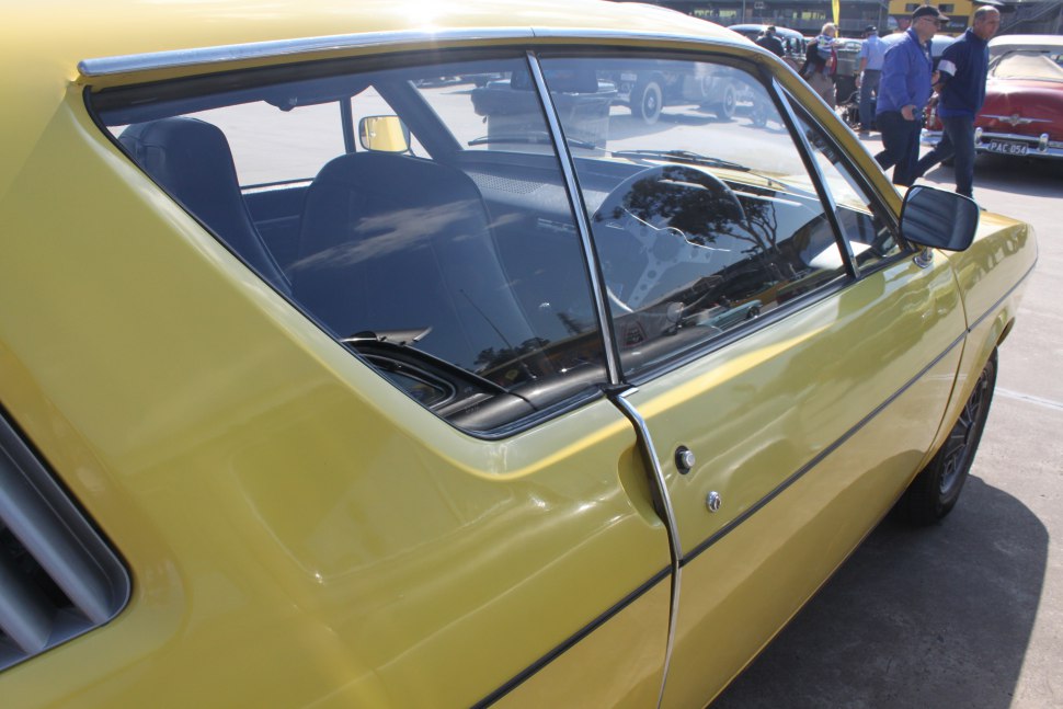 Yellow car side with angular rear window vent and black trim line