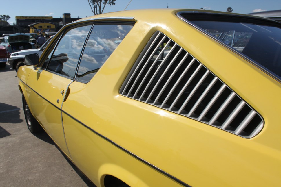 Yellow vintage coupe with distinctive rear window louvers
