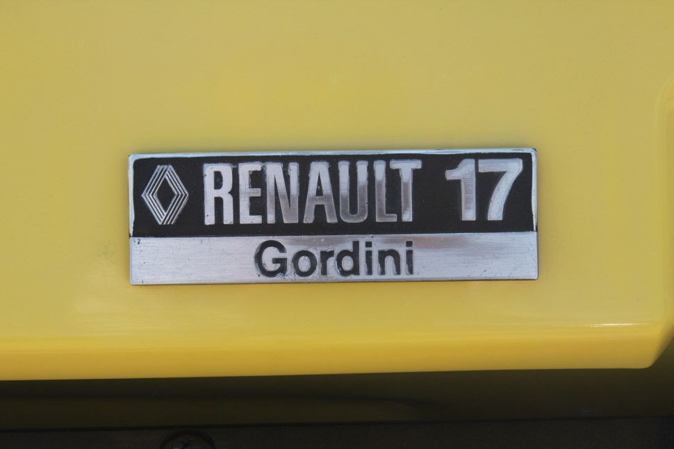 Close-up of Renault 17 Gordini emblem badge on yellow background