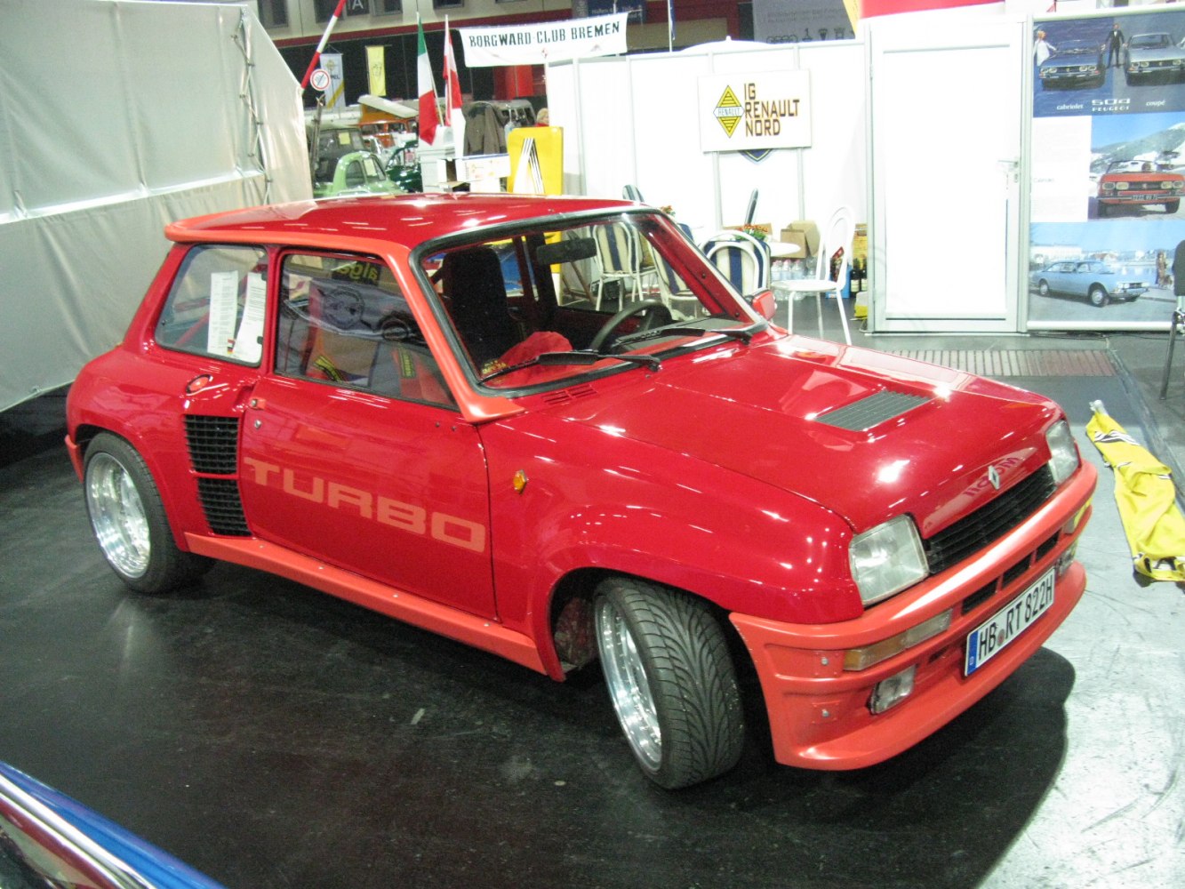 Red sporty hatchback with wide fenders and turbo decal