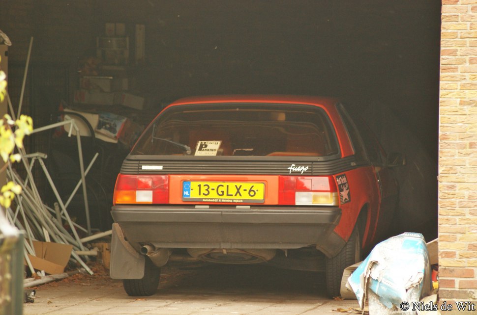 Rear view of a classic hatchback with vintage taillights and license plate.