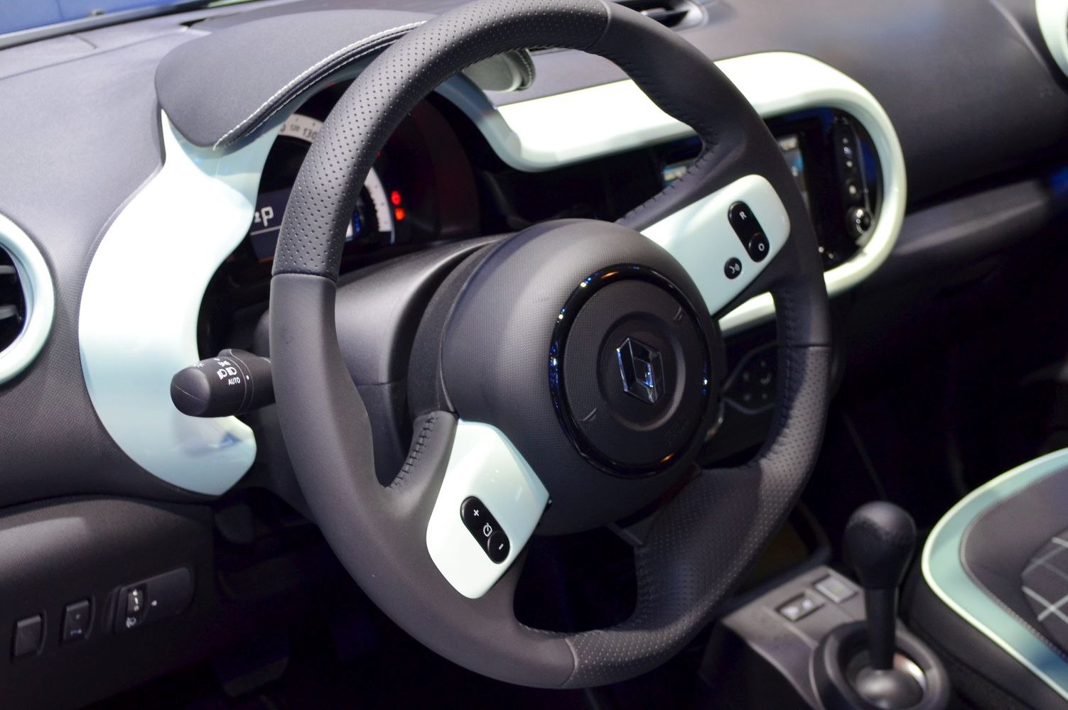 Close-up of steering wheel and dashboard with control buttons.