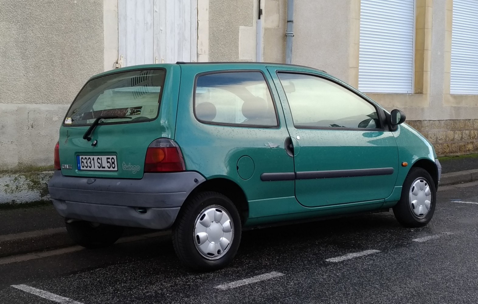 Rear side view of compact hatchback from early 1990s with rounded design