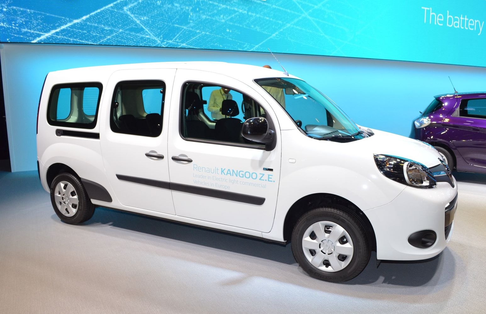 Side view of electric compact commercial van with large windows and sliding door
