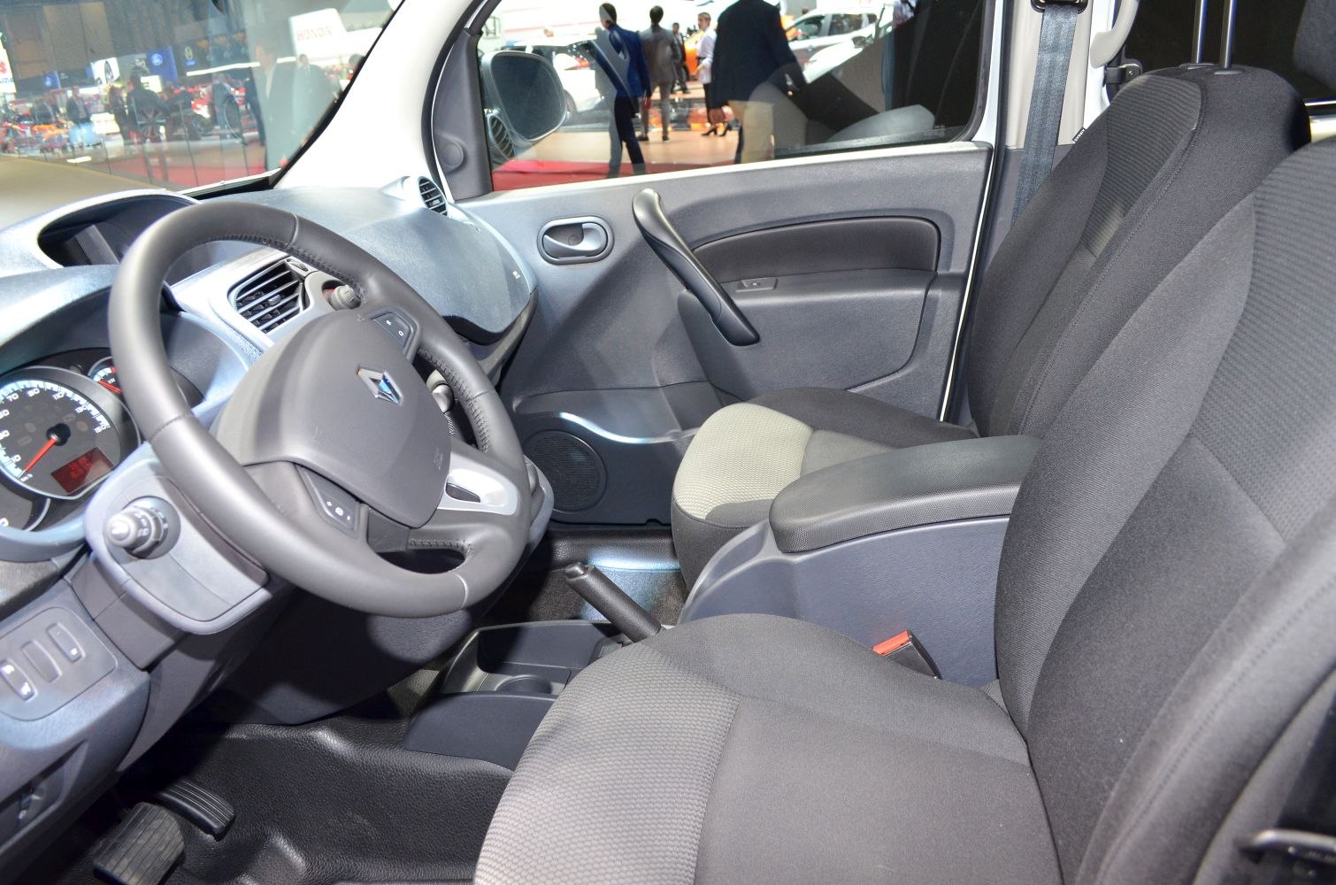 Steering wheel, dashboard, front seats, and door panel of a compact van interior