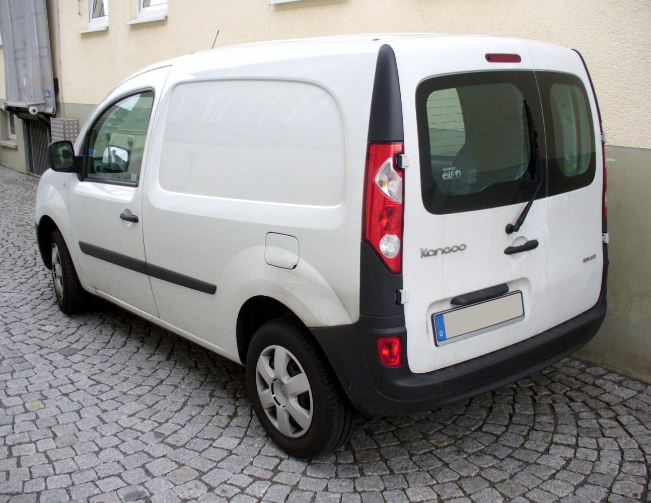 Rear side view of white compact cargo van with rear window and wiper