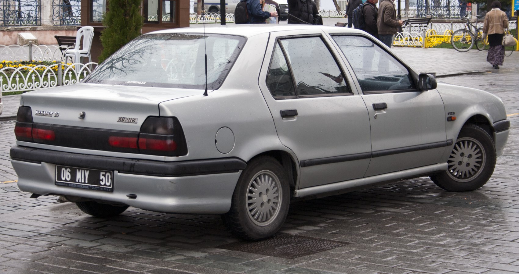 Rear side view of silver 4-door sedan with classic taillights and alloy wheels.