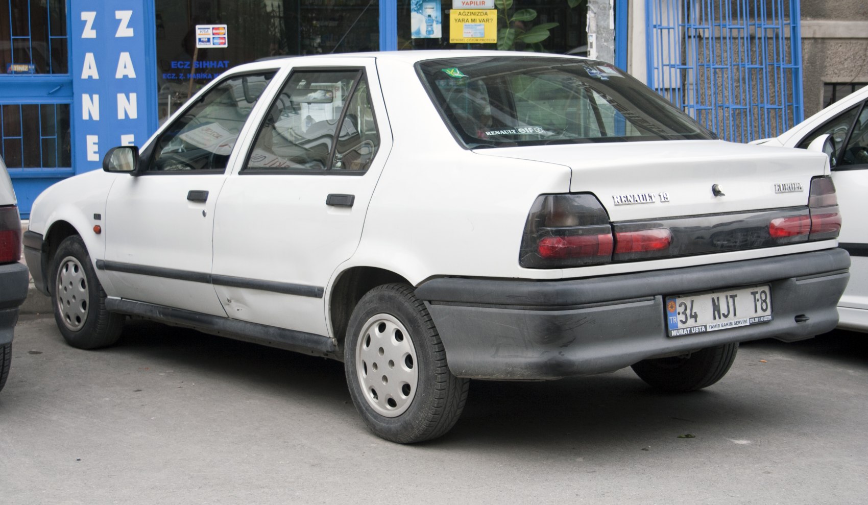 White four-door sedan rear side with distinct taillights and black rear bumper