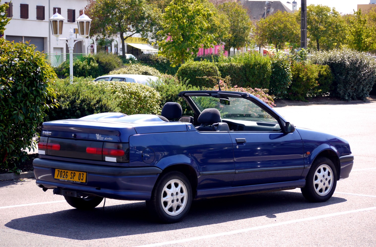 Blue convertible with rear and side view in parking lot.