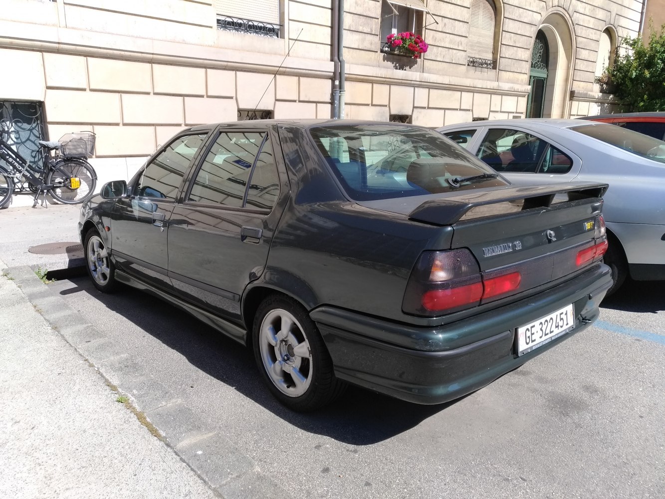 Rear view of a 1990s sedan with spoiler and alloy wheels