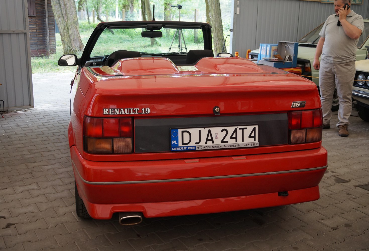 Rear view of red convertible with 16V badge and soft top down