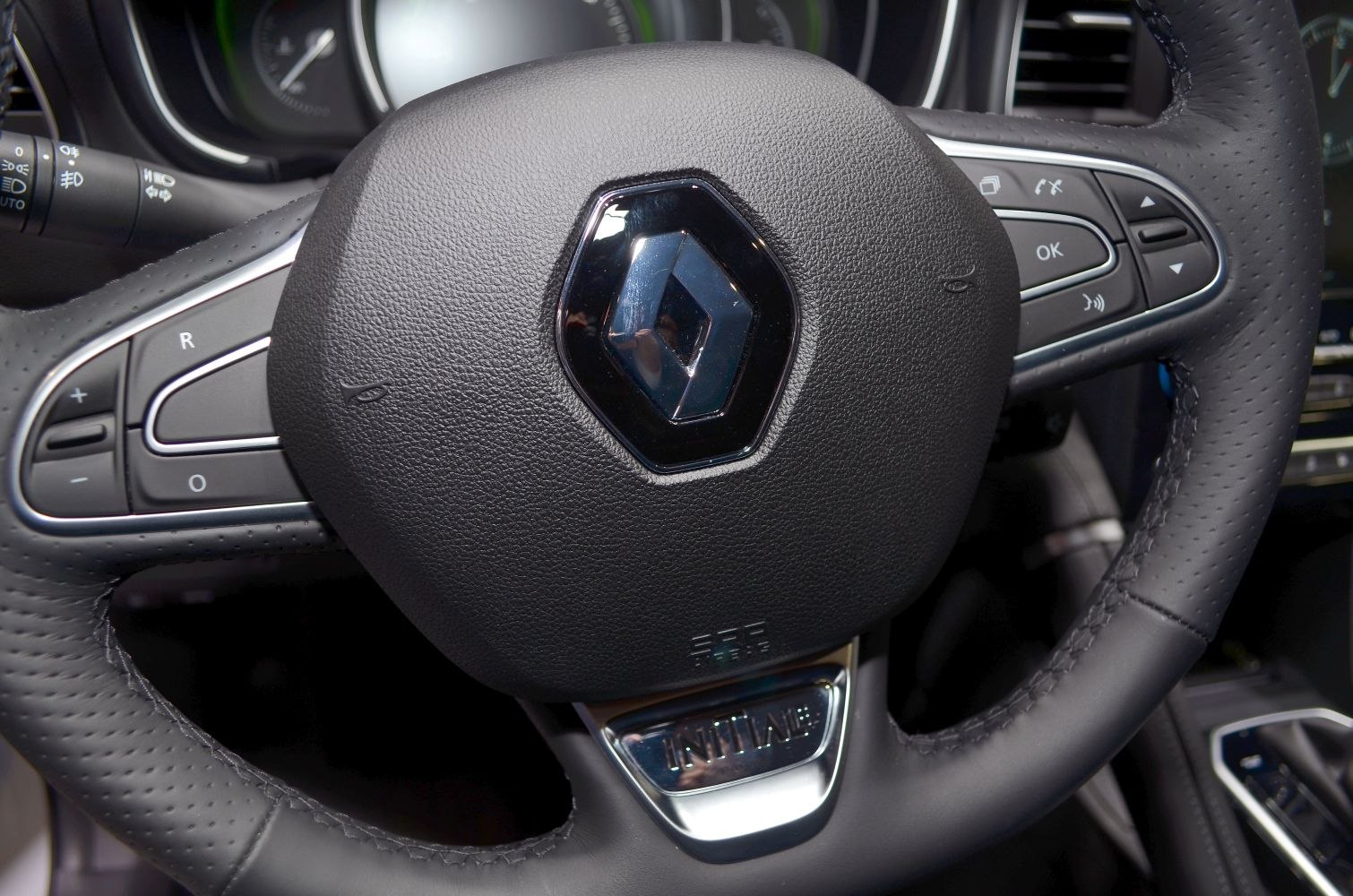 Close-up of steering wheel with control buttons and leather texture