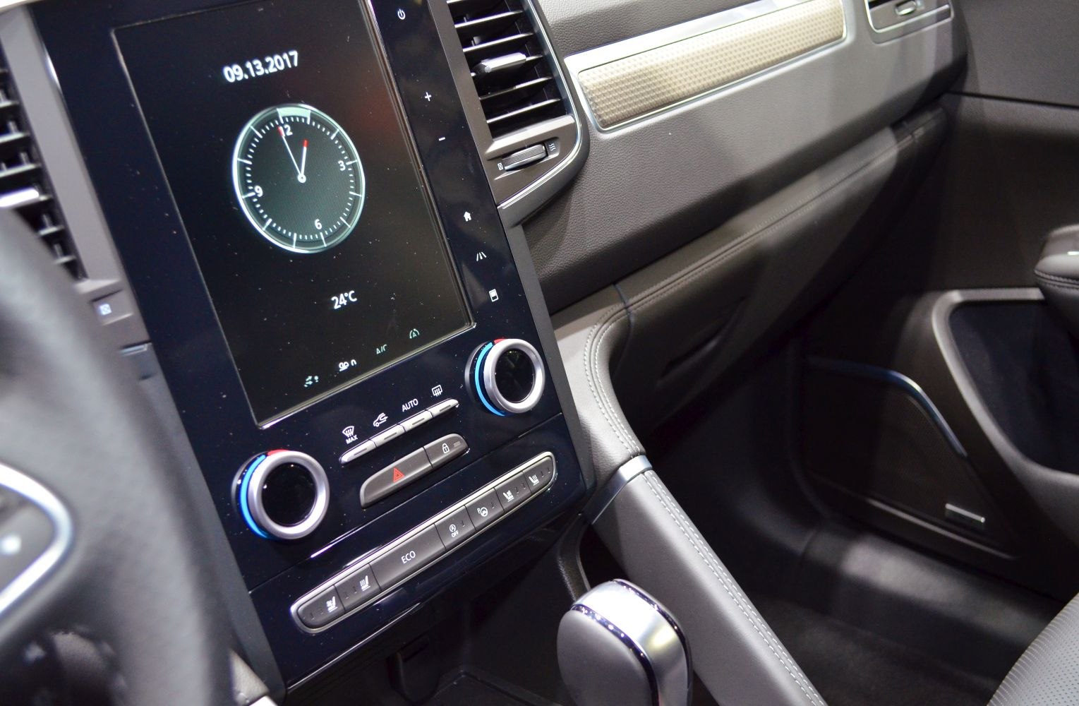 Close-up of touchscreen and climate control knobs in vehicle interior.
