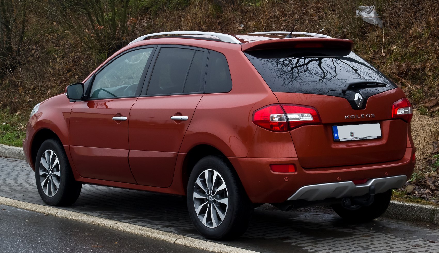 Rear side view of mid-size SUV with alloy wheels and roof rails