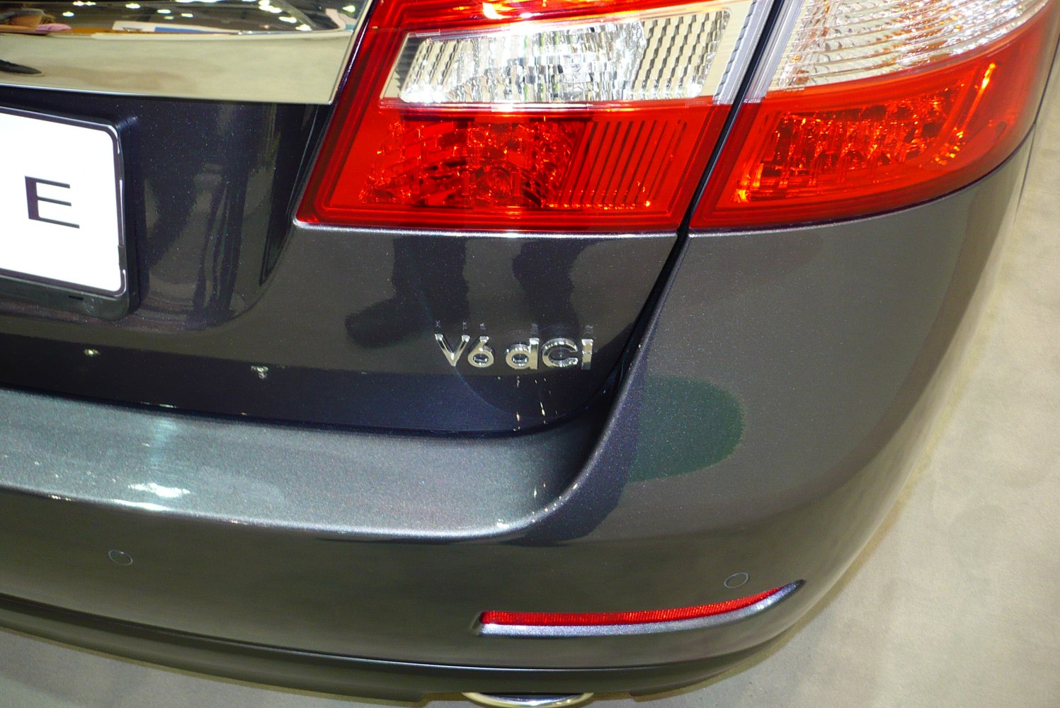 Close-up of rear taillight and V6 dCi badge on dark gray car section