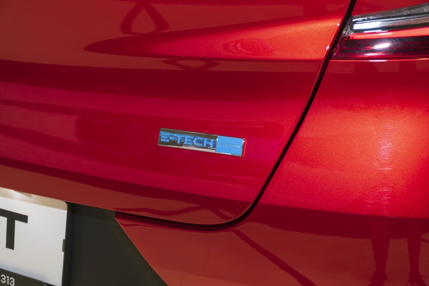 Close-up of E-Tech Hybrid badge on red rear panel