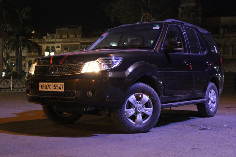 Black SUV with front angle view, illuminated headlights, alloy wheels