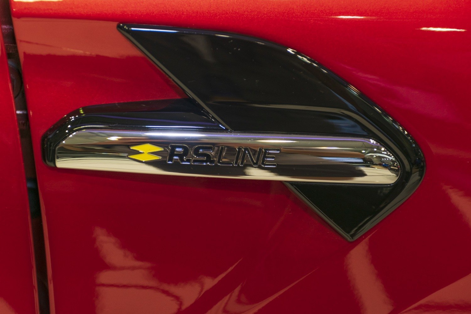 Close-up of RS Line side badge on red vehicle.