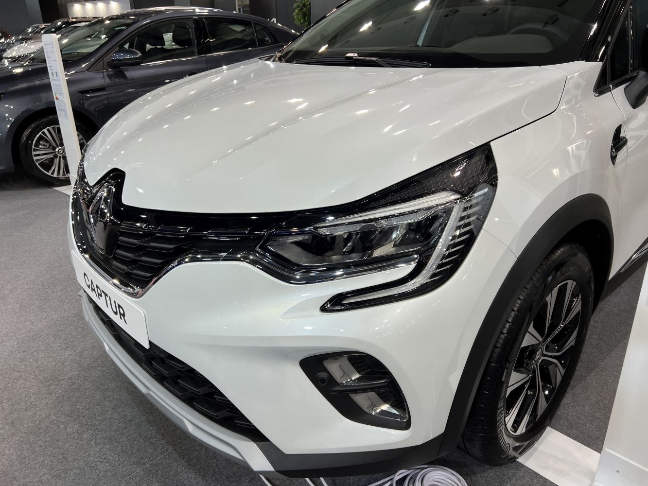 Close-up of front headlight and grille with LED elements and sleek design.