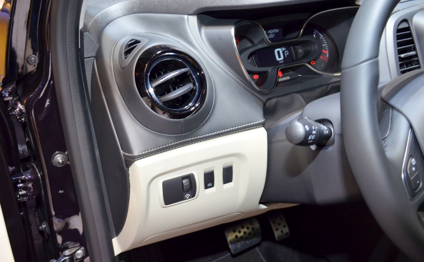 Close-up of circular air vent and dashboard control switches