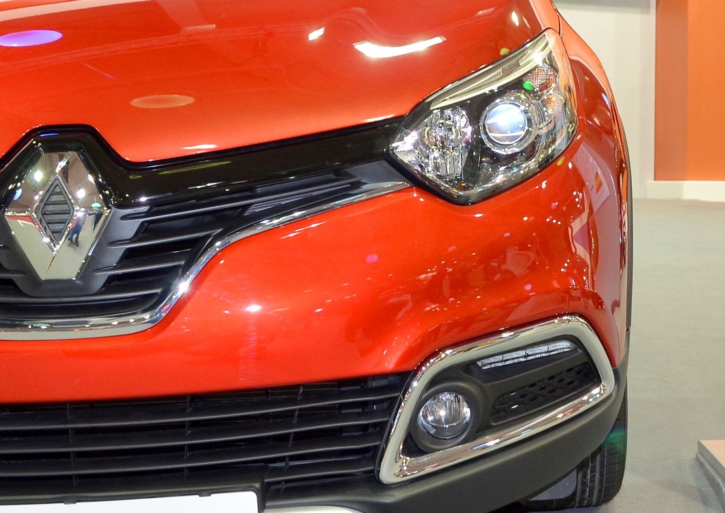 Close-up of front grille and headlight with chrome trim and fog light