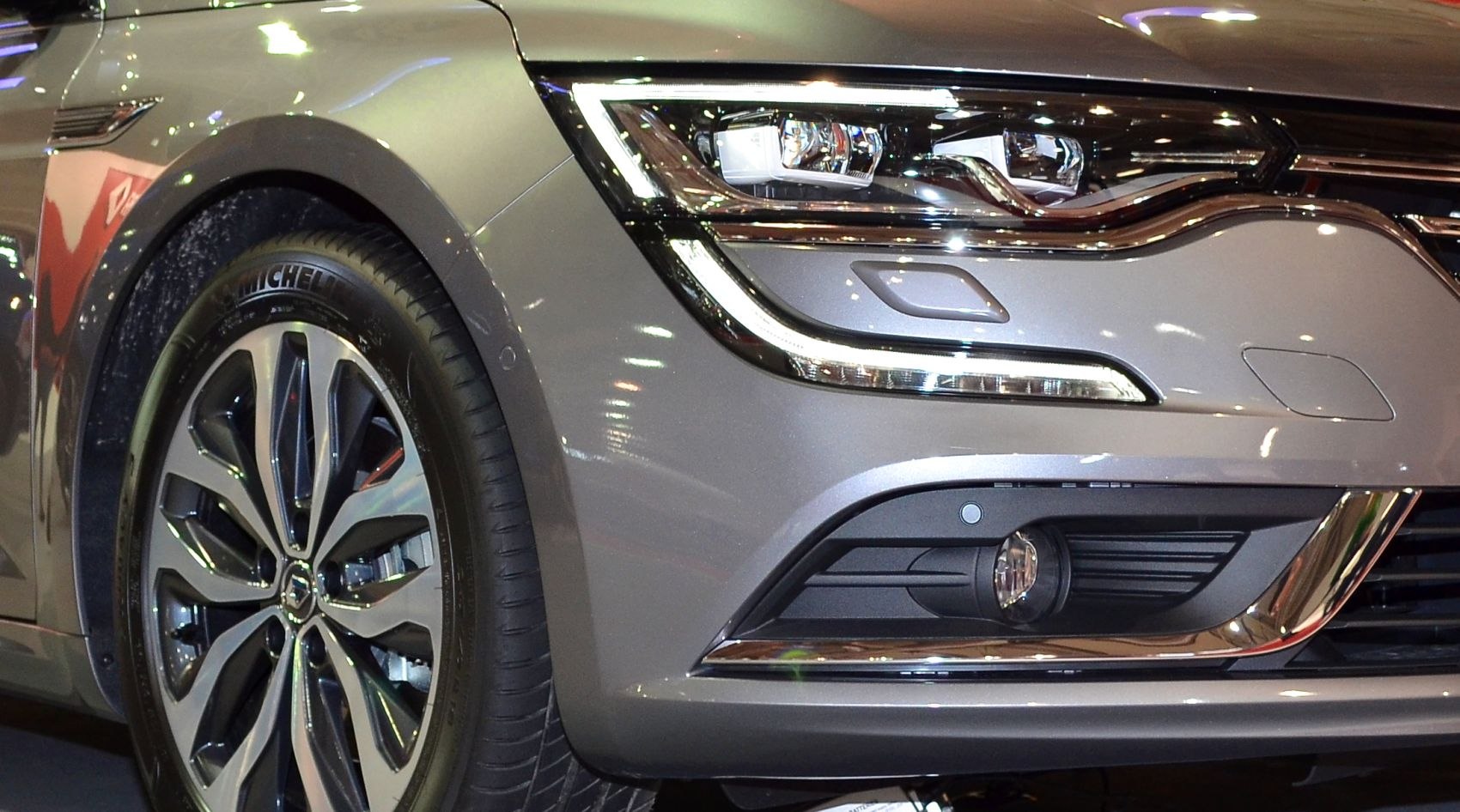 Close-up of front headlight and alloy wheel with sleek design